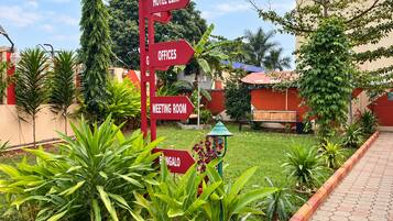 Señal direccional roja con varias flechas que indican diferentes servicios del hotel, como el hotel mismo, oficinas, una sala de reuniones y bungalows.