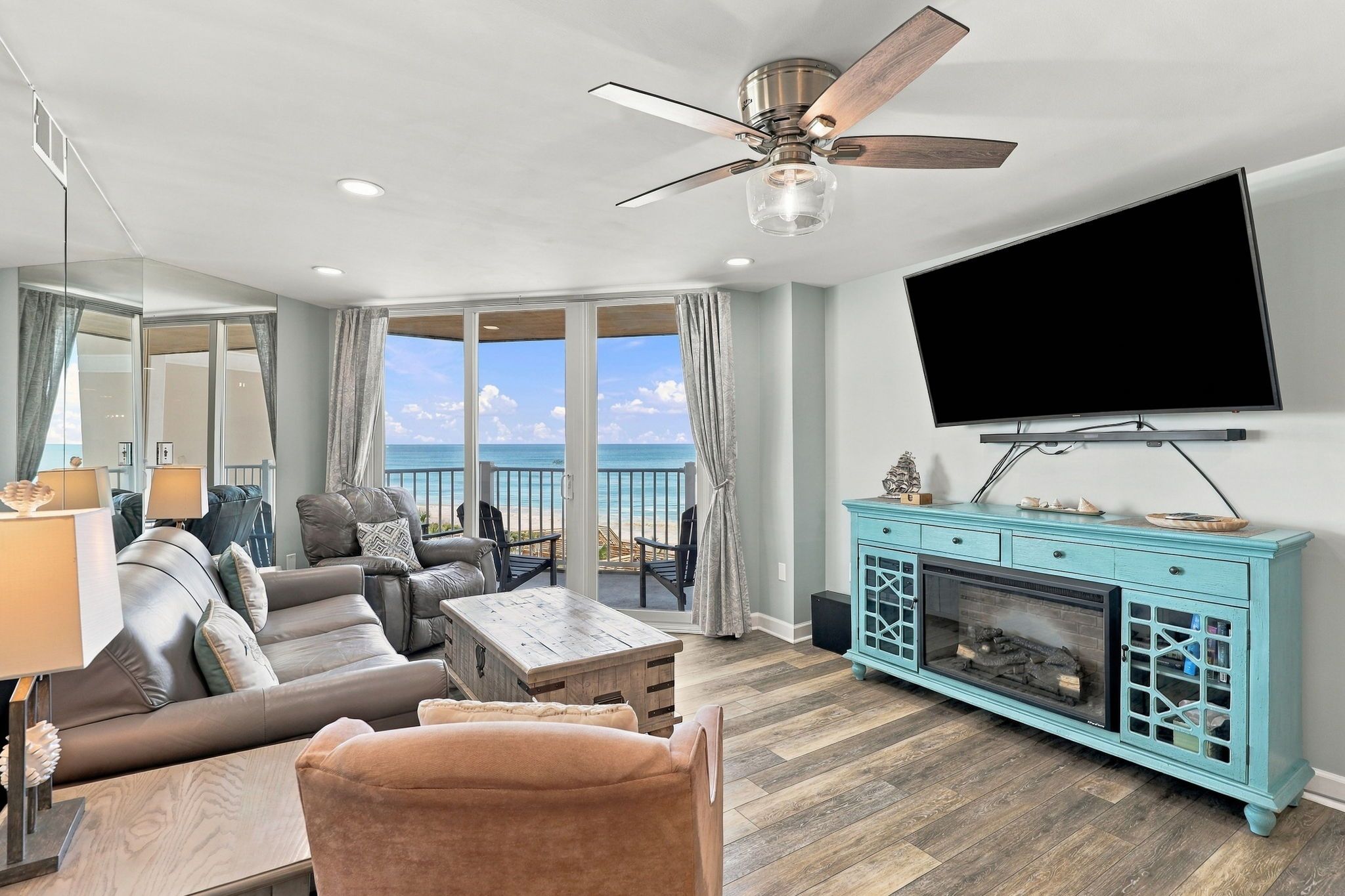 A living room with a sofa, a coffee table, a fireplace, and a television.