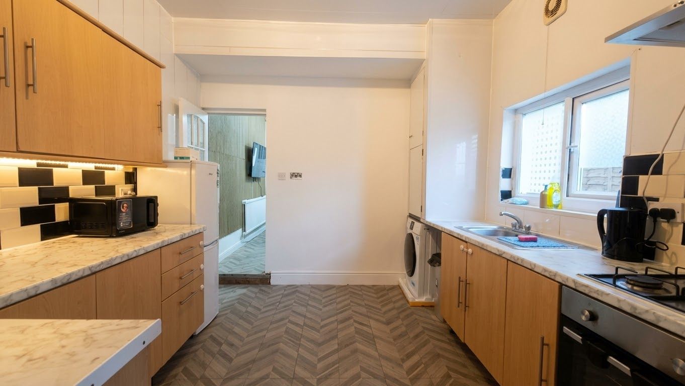 A compact kitchen with a microwave, stove, and sink.