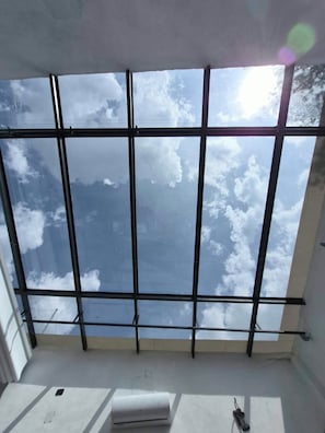 A room with a large window offering a view of the sky and clouds. - Hotel Boutique Santa Teresa (San Andrés Cholula, Puebla)