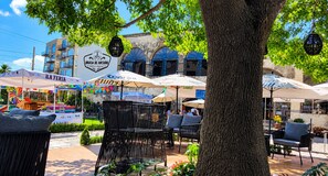 An outdoor seating area with tables and chairs, surrounded by trees and umbrellas. - Hotel Boutique Santa Teresa (San Andrés Cholula, Puebla)
