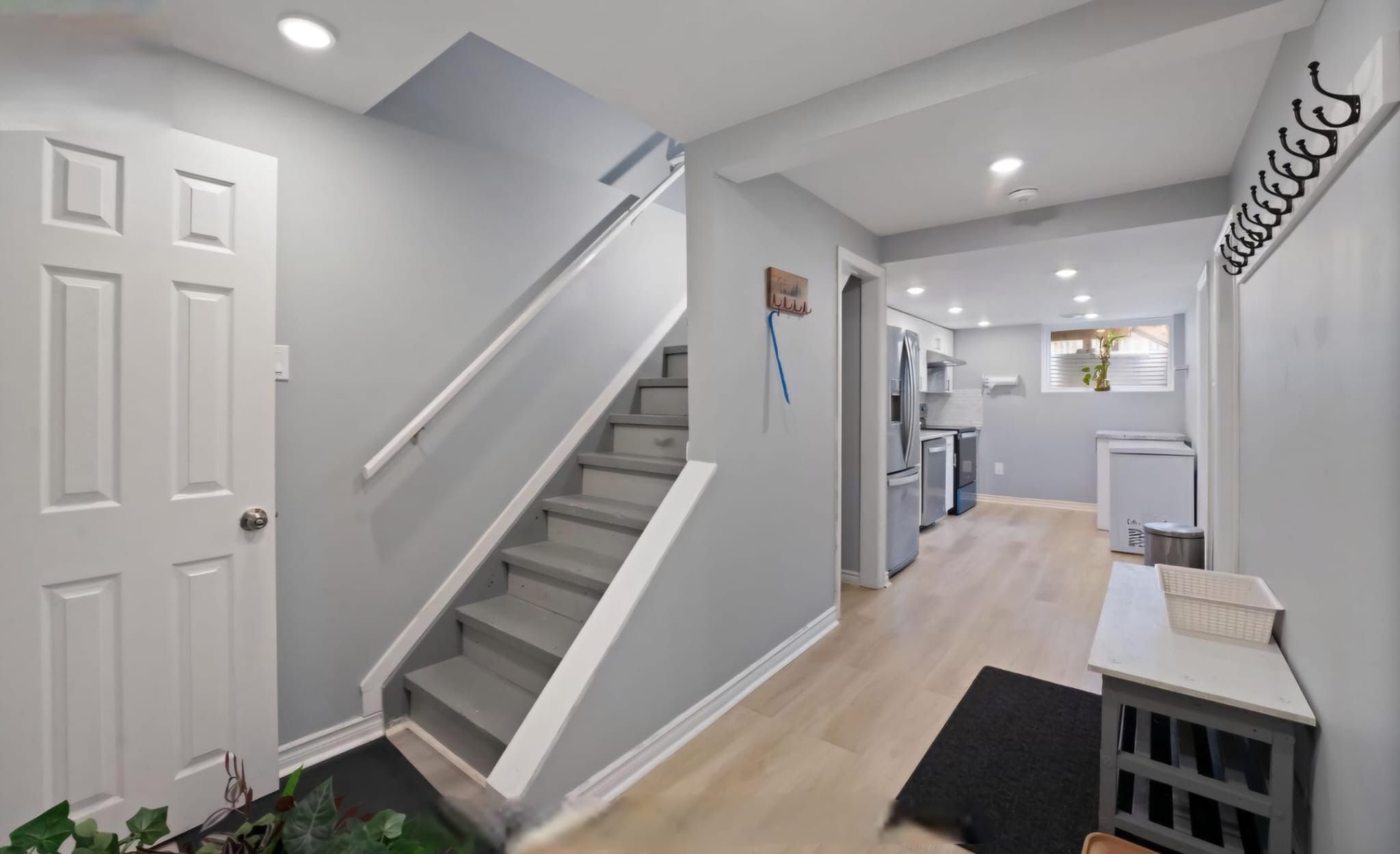 A modern interior with a staircase, a kitchen area, and a dining space.