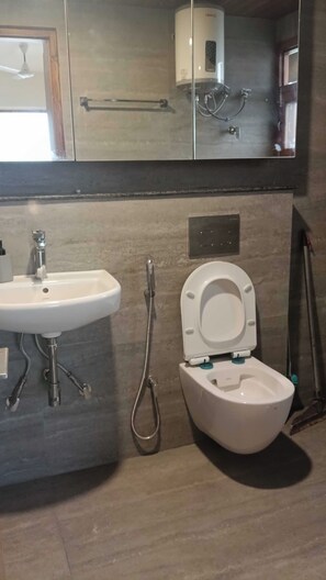 Ein Badezimmer mit einem weißen Waschbecken, einer Toilette und einer Dusche.