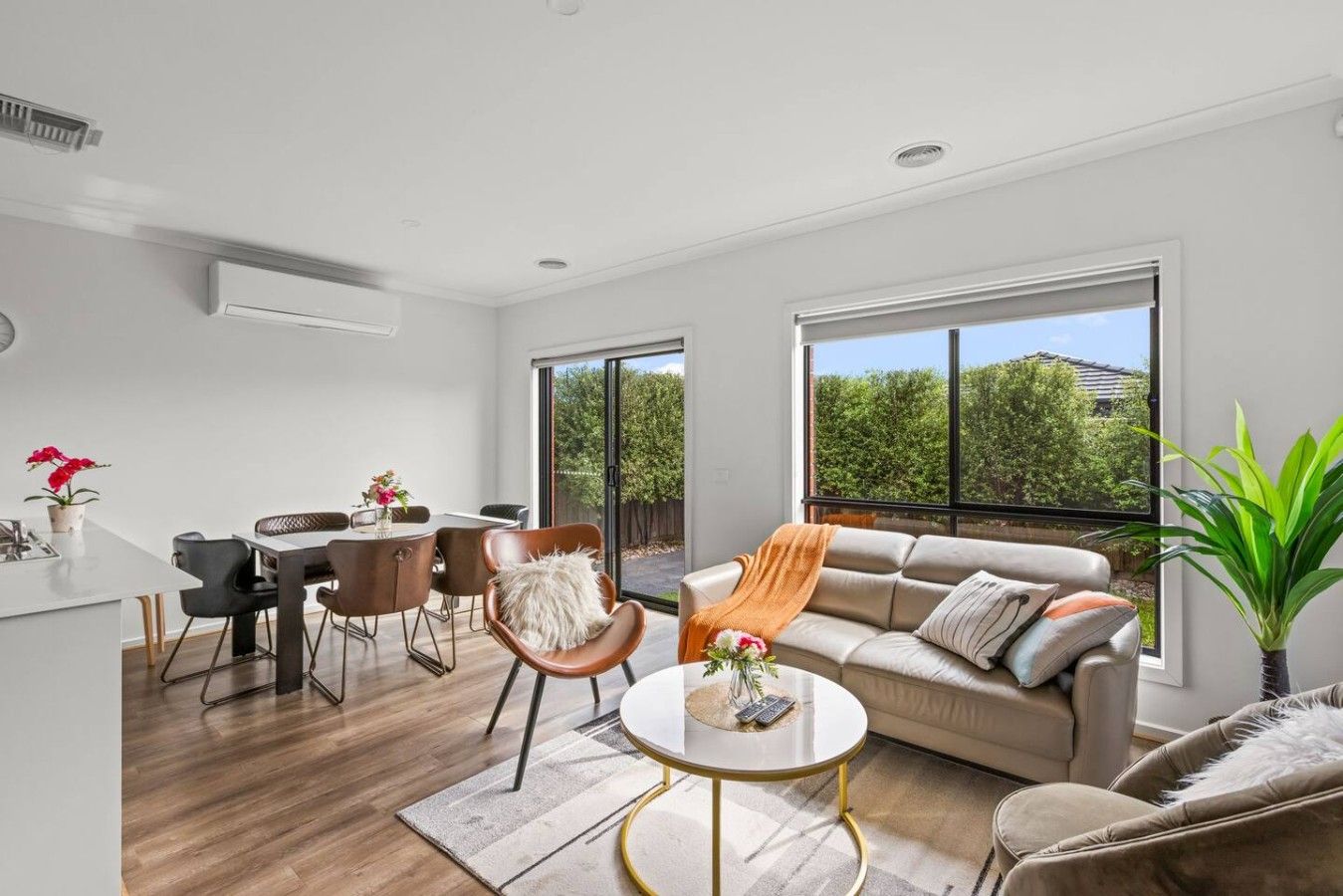 A modern living room with a sofa, coffee table, and dining area.