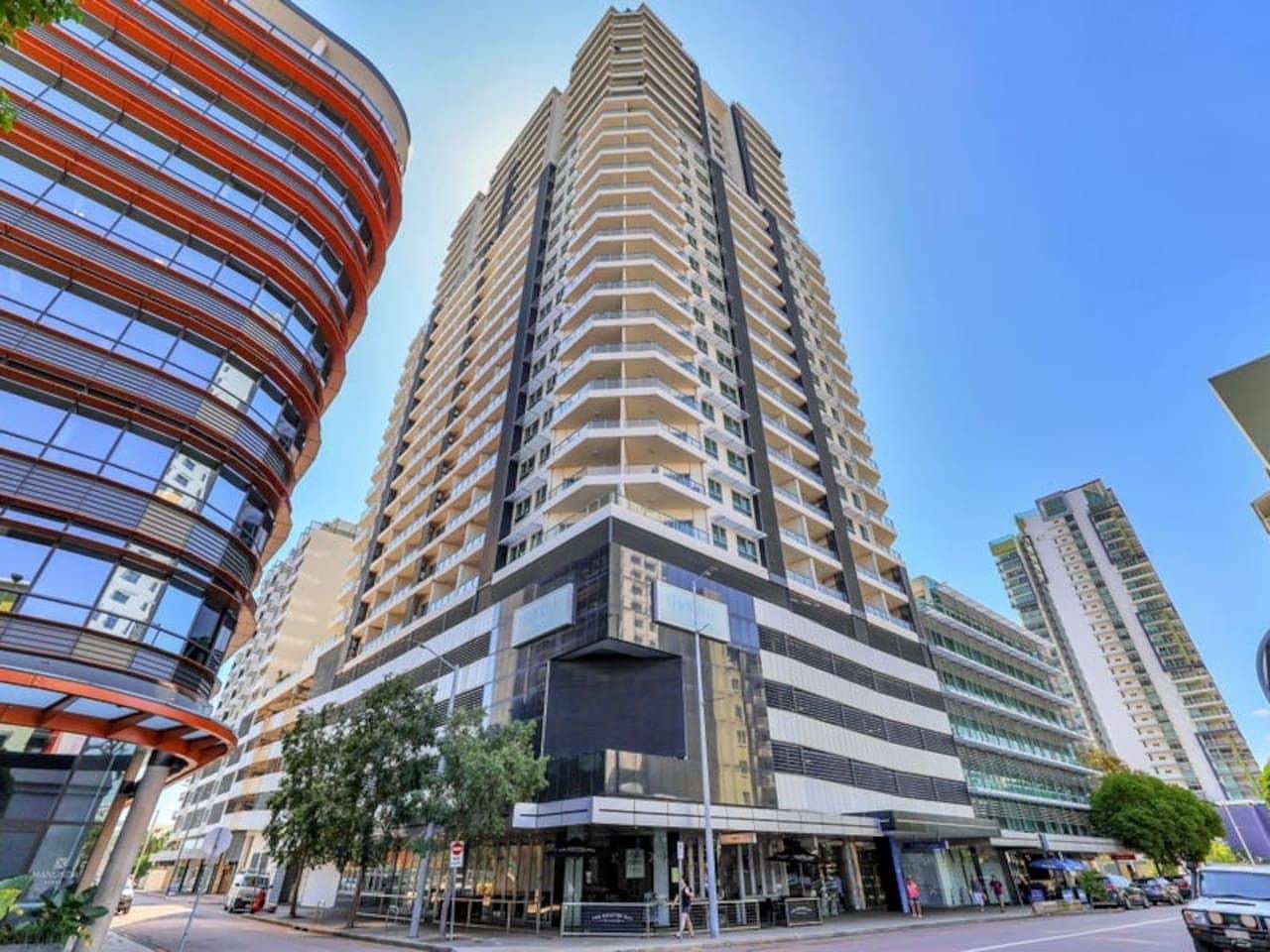A high-rise building with a modern design, featuring multiple balconies and a glass facade.