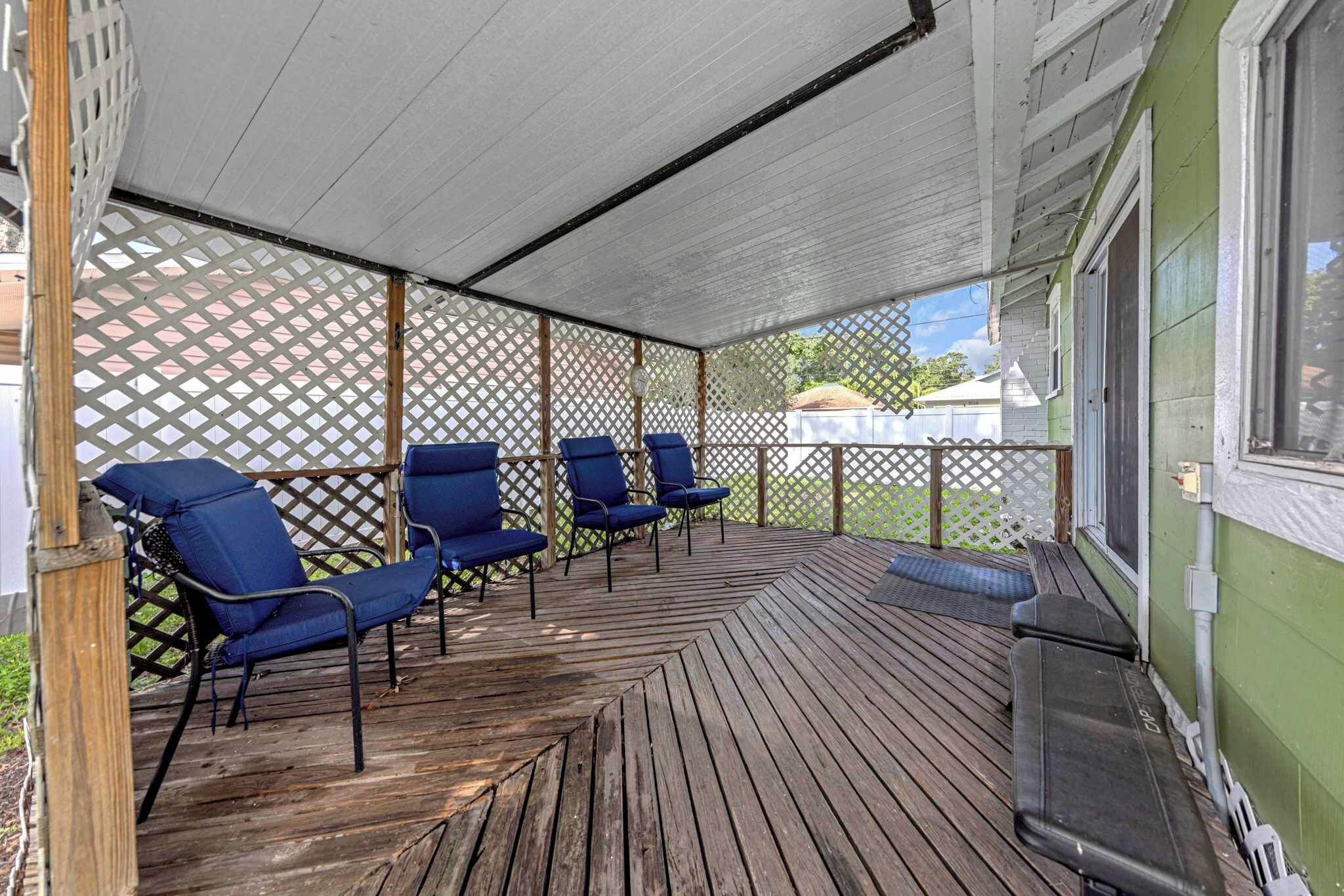 Un espace extérieur abrit é, doté d’un plancher en bois et de chaises bleues.