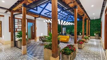 A spacious lobby with a high ceiling, wooden beams, and a checkered floor pattern.