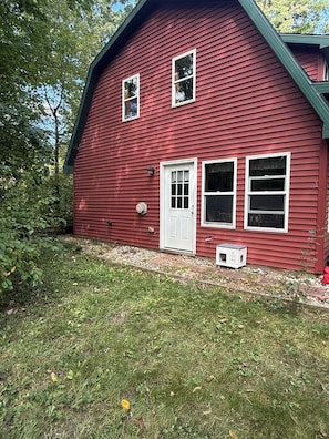 A red wooden house with a white door, two windows, and a small shed. - Peaceful getaway in Amish Country (Clare)