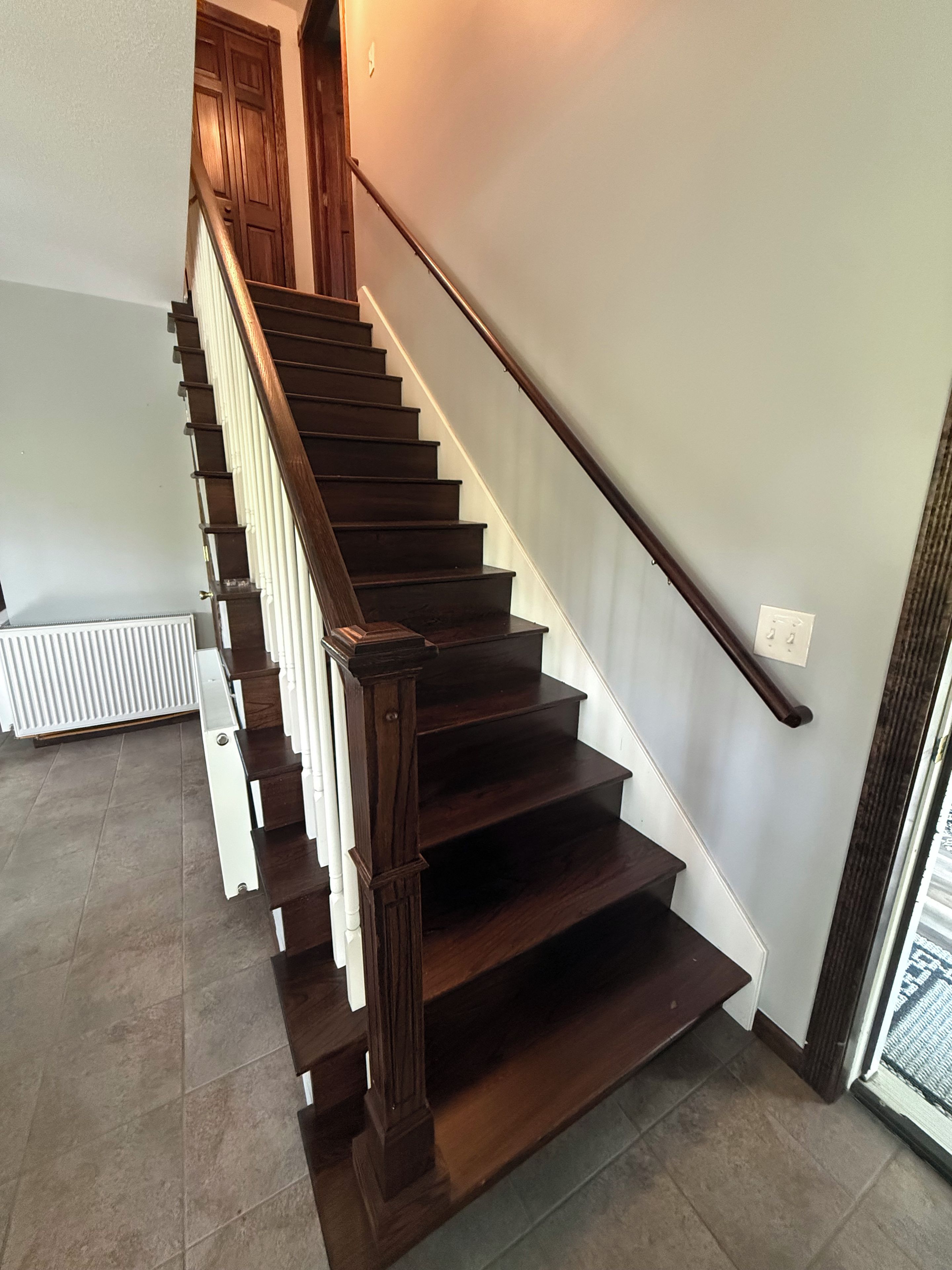 Un escalier en bois avec une rampe, menant à l’étage supérieur.