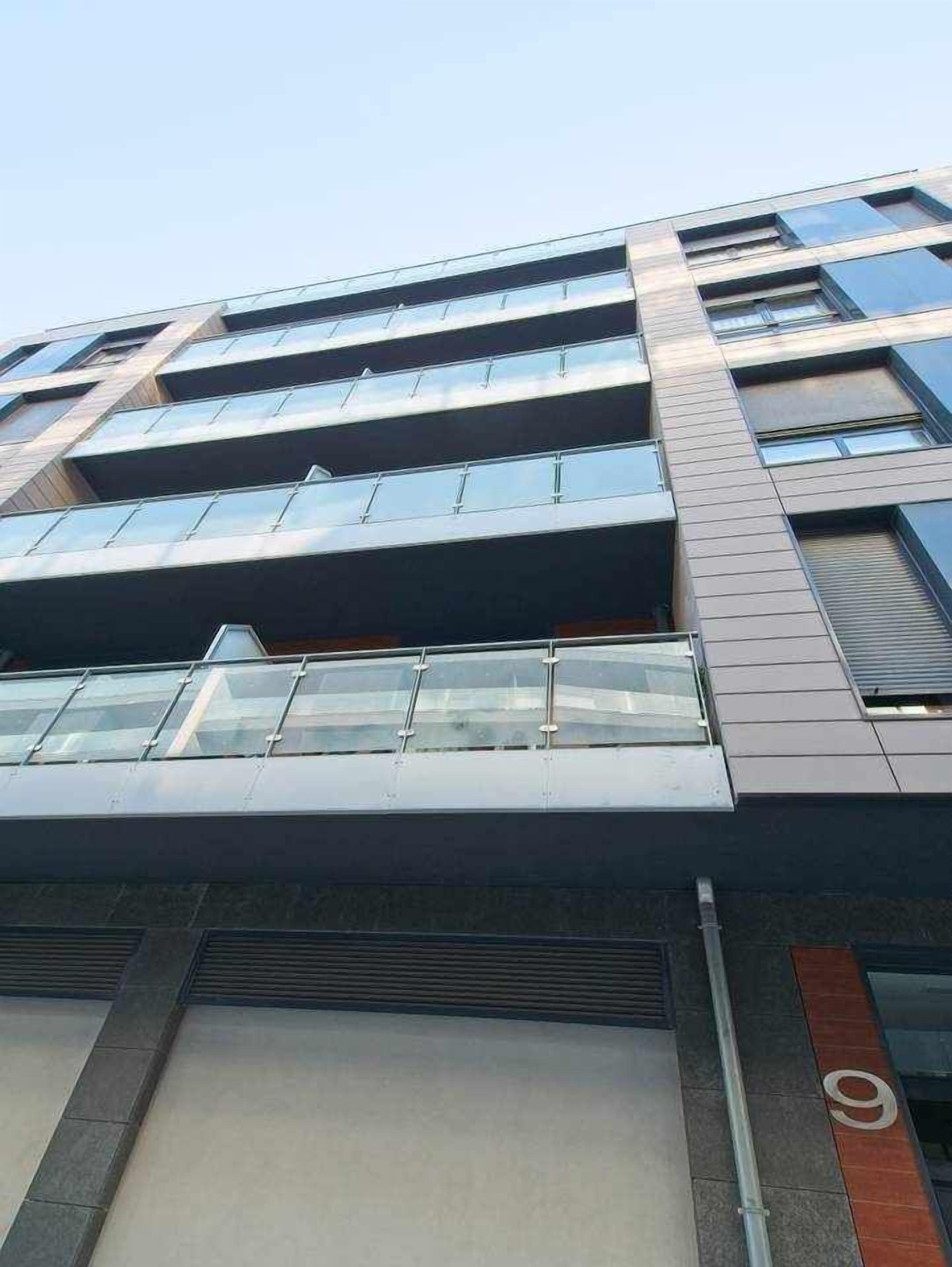 Un edificio de varios pisos con un diseño arquitectónico moderno, que destaca por sus grandes ventanales y techo plano.