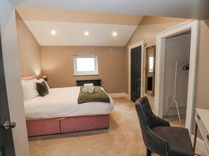 Un dormitorio con una cama, una ventana, un radiador y una puerta que da a un baño.