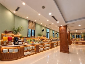 Zona de bufé con varias estaciones de comida, incluyendo 'Ensalada' y 'Banh'.