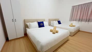 A hotel room with two beds, a wardrobe, and a window with curtains.