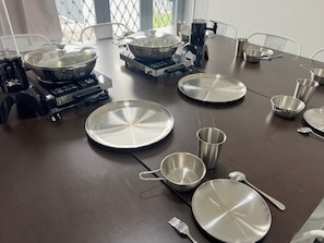 Una mesa de comedor con diferentes utensilios de cocina, como platos, tazones y una tetera.