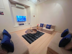 Una sala de estar moderna con un televisor de pantalla plana, una mesa de centro y un juego de sofá.