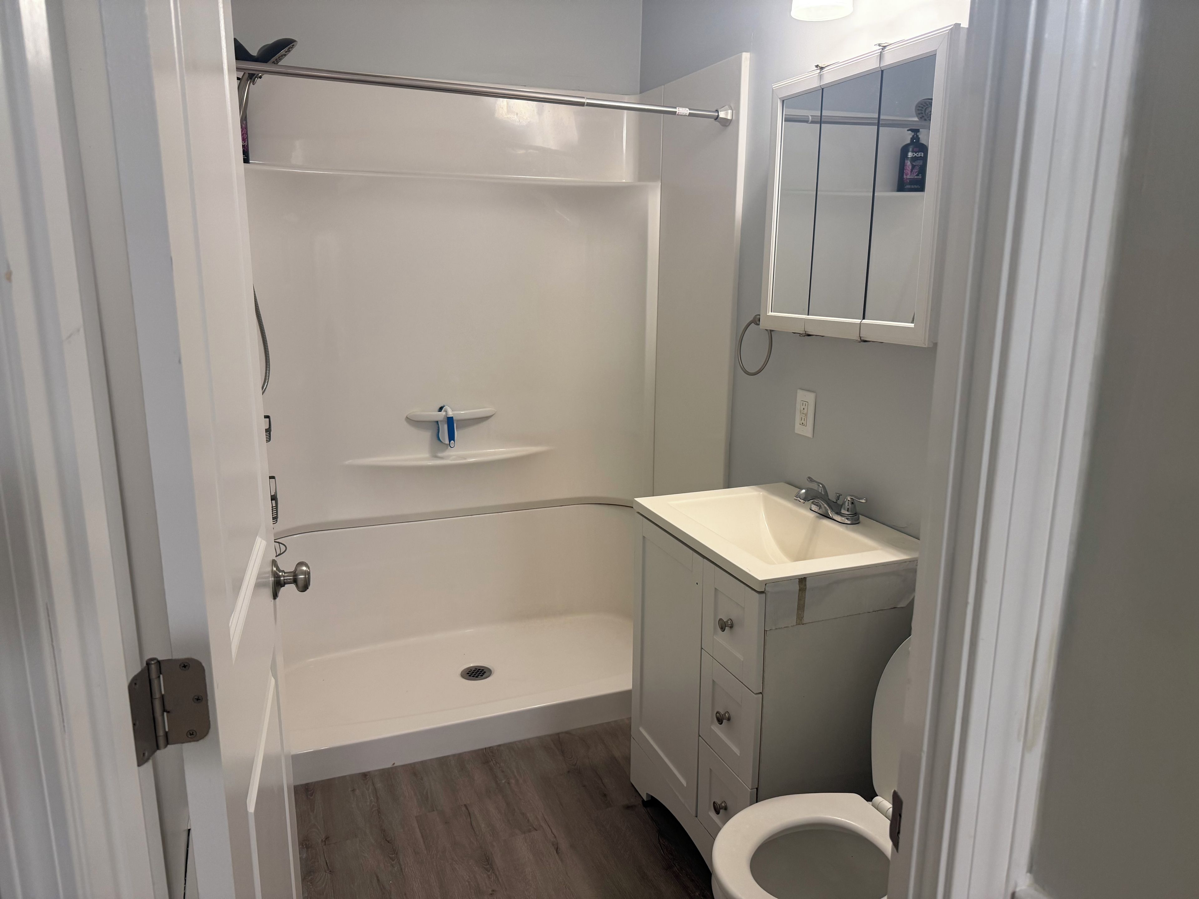 A bathroom with a bathtub, a sink, a toilet, and a mirror.