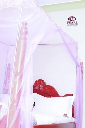 A four-poster canopy bed with a wooden frame and white bedding. - Pearl Express Hotel Kabale (Kabale)