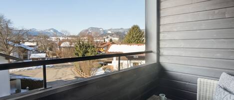 A balcony with a view of a snowy landscape and mountains.