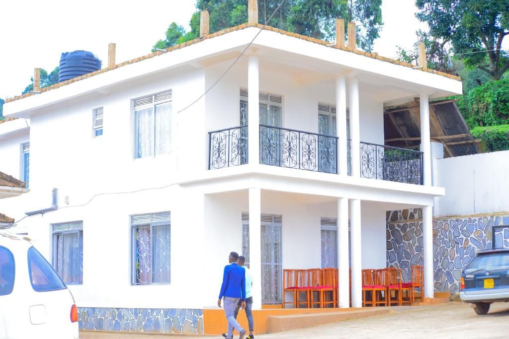 A two-story building with a balcony, outdoor seating, and a parked car.