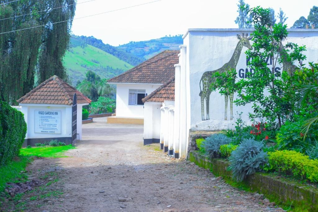 A pathway leading to a building with a sign for Kigezi Gardens Inn.