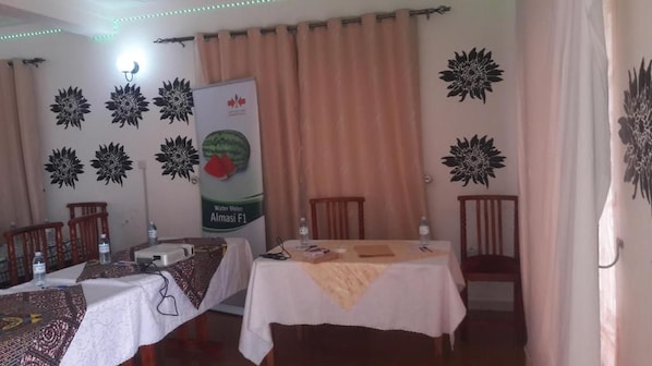 Una habitación con dos mesas, sillas, un banderín y adornos en la pared.