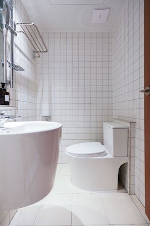 A modern bathroom with a freestanding bathtub, a toilet, and a shower area. - Gem Hostel Seoul (jung-gu)