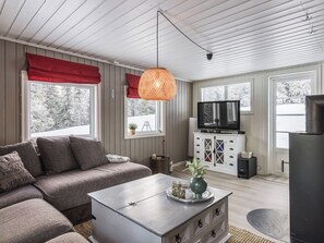 A modern living room with a sectional sofa, a coffee table, a television, and a fireplace.