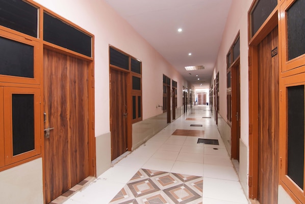 Un pasillo con puertas de madera y suelo de baldosas.