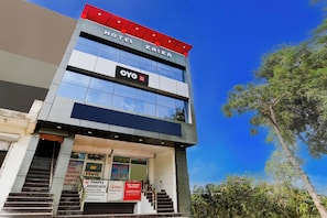 A hotel building with a prominent sign for 'OYO Hotel Kalki' and multiple advertisements for local businesses. - Hotel O Kalka (Faridabad)