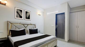 A hotel room with a bed, a wardrobe, and two wall-mounted light fixtures.