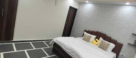 Un dormitorio moderno con cama, ventilador de techo y aire acondicionado.