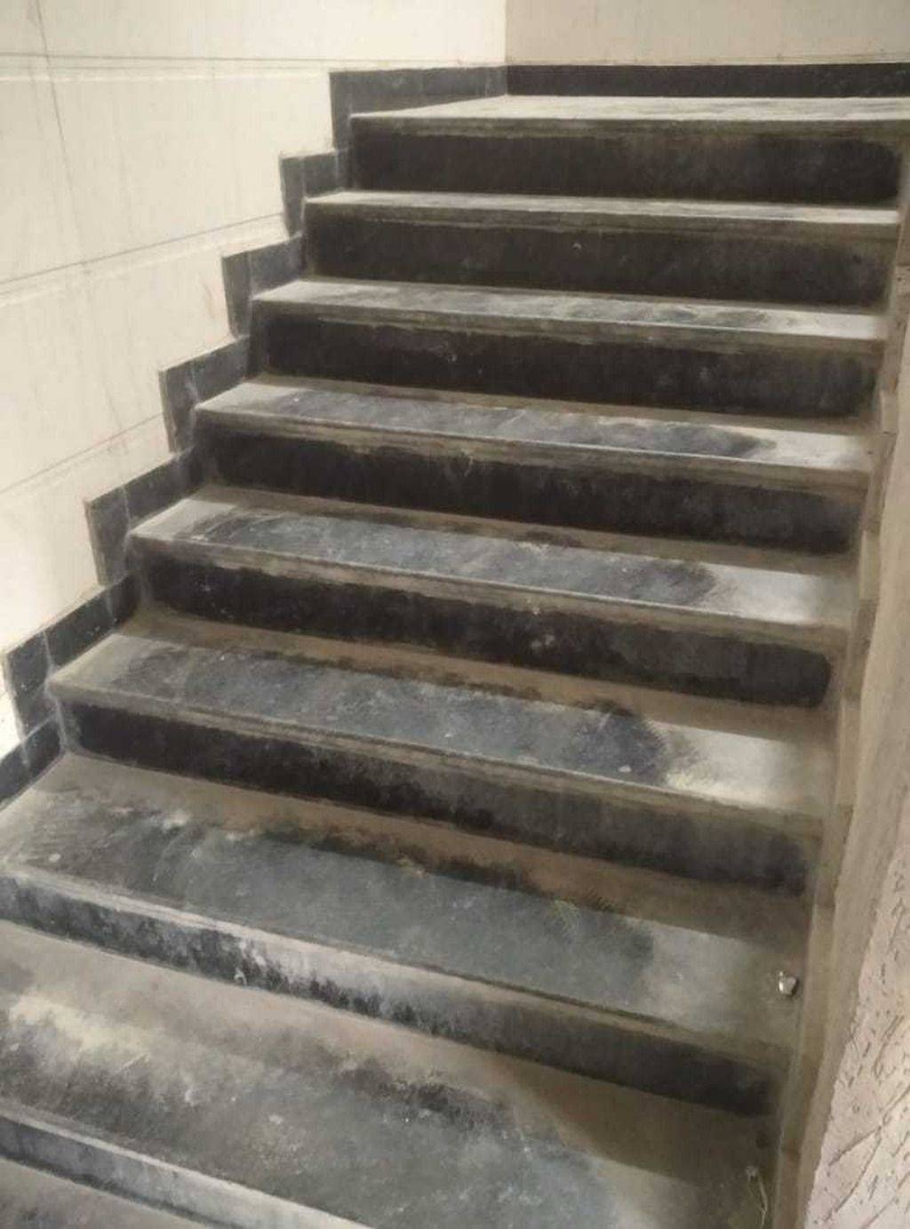 Eine Treppe aus schwarzem Marmor, die nach oben führt.