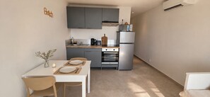 A compact kitchen with grey cabinets, a built-in oven, and a microwave. - New Listing (Saint-Florent)