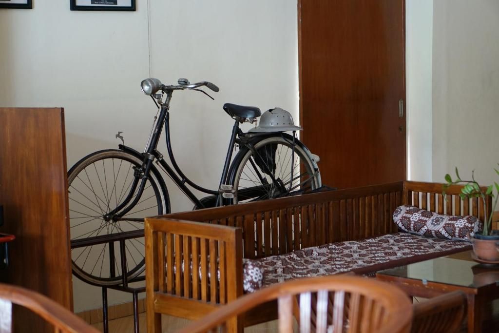 A room with a wooden bench, a bicycle, and a door.
