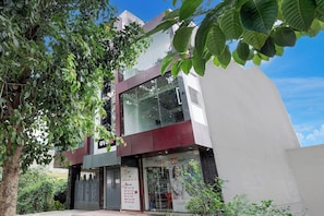 A hotel with a modern facade, a large glass window, and a signboard advertising hotel services. - Hotel O The King Heaven (Farrukhabad)