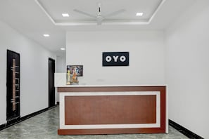 A reception area with a marble counter, a ceiling fan, and a sign that reads 'OYO'. - Hotel O The King Heaven (Farrukhabad)