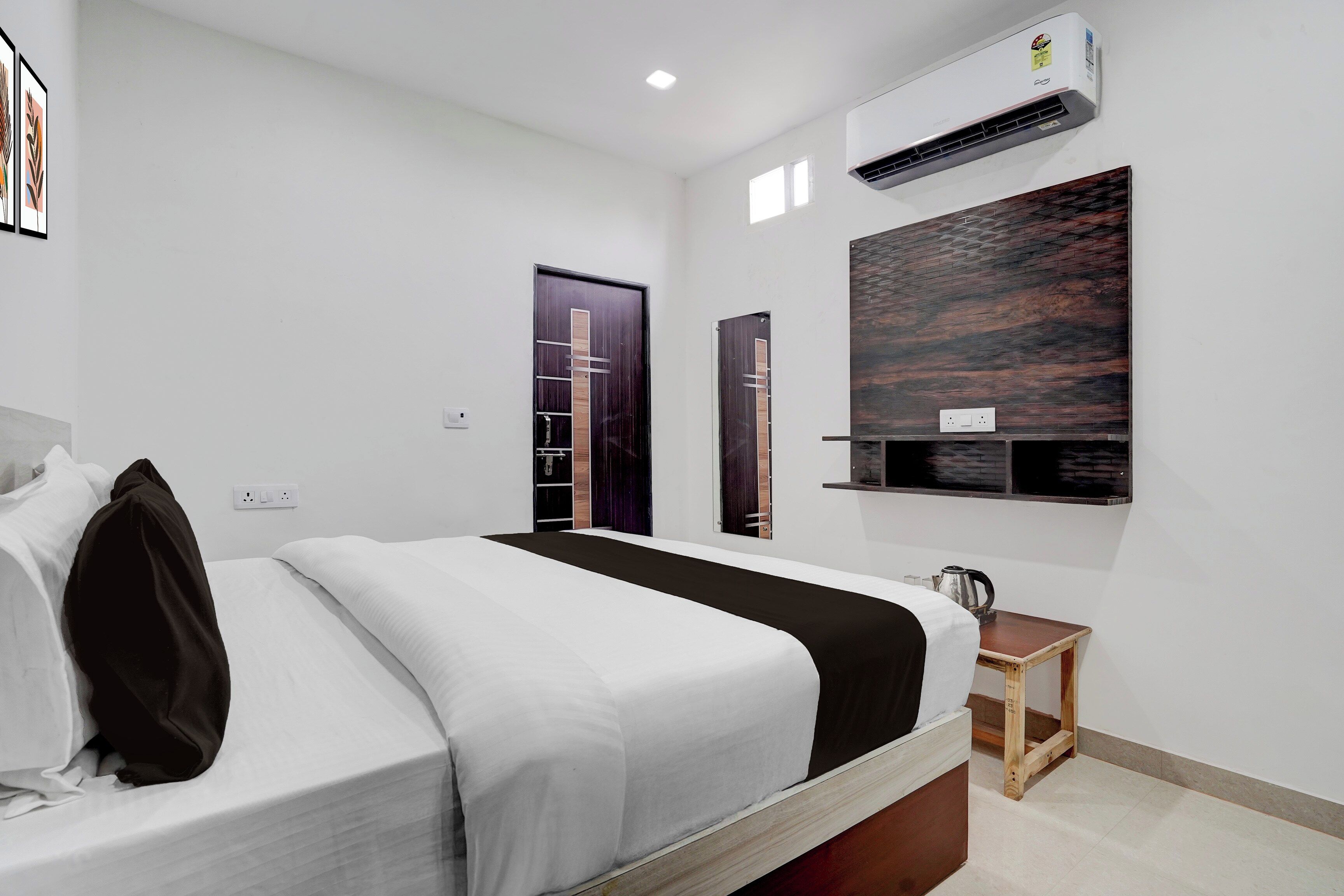 Une chambre moderne comprenant un lit, une table de chevet, un climatiseur fixé au mur et un panneau décoratif.