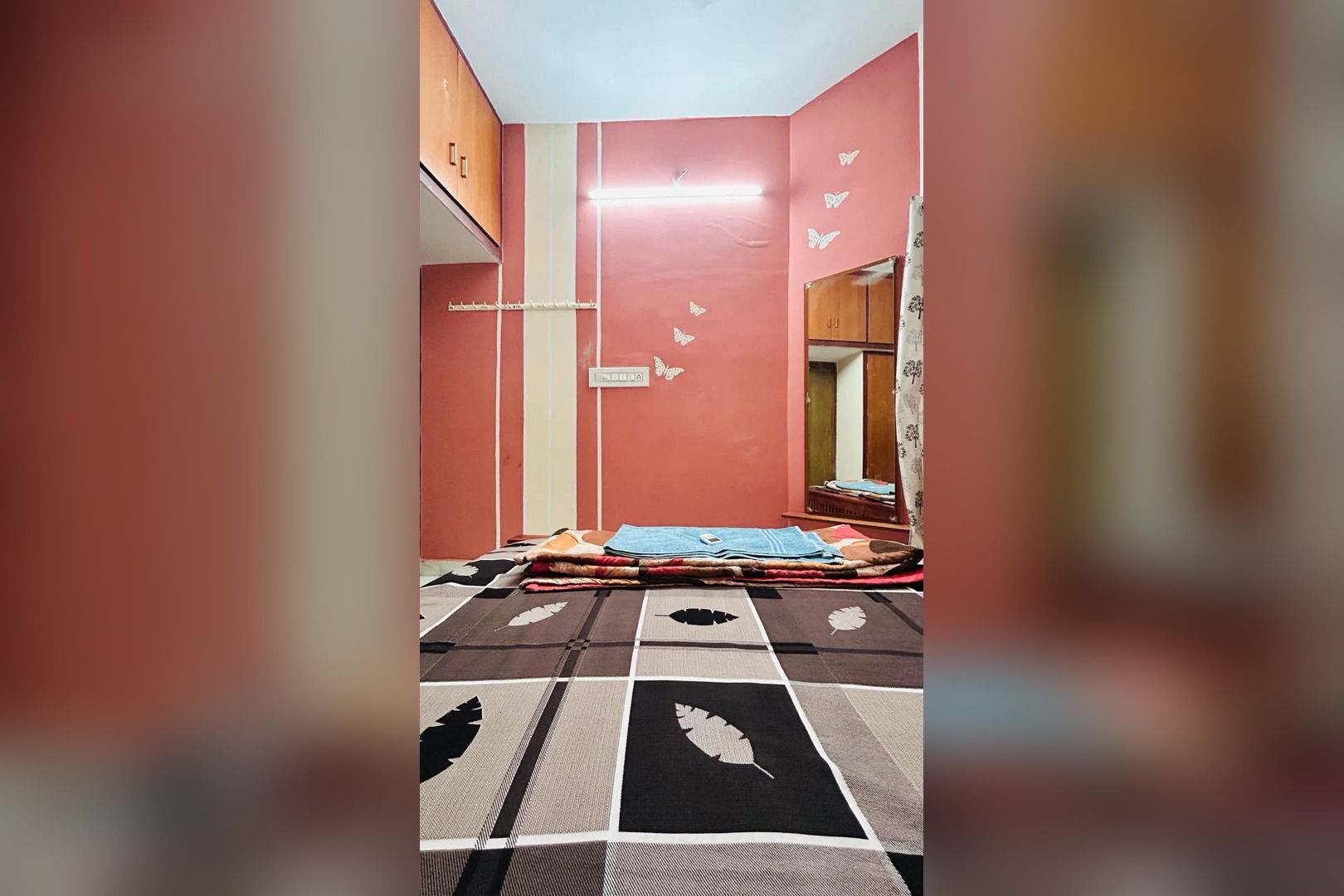 A room with a bed, a wardrobe, and a mirror.