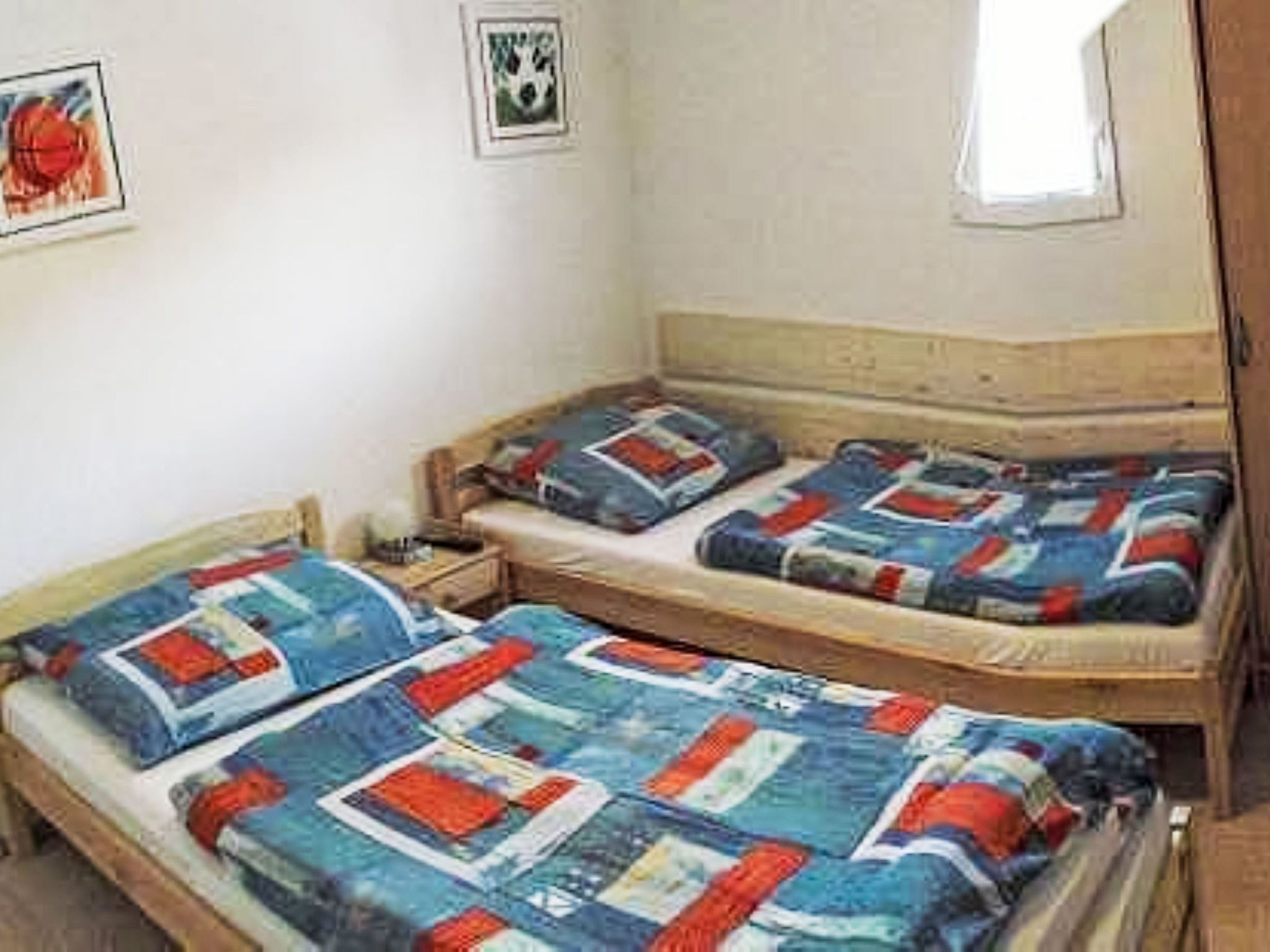 Una stanza con due letti di legno, ognuno con copripiumino trapuntato.