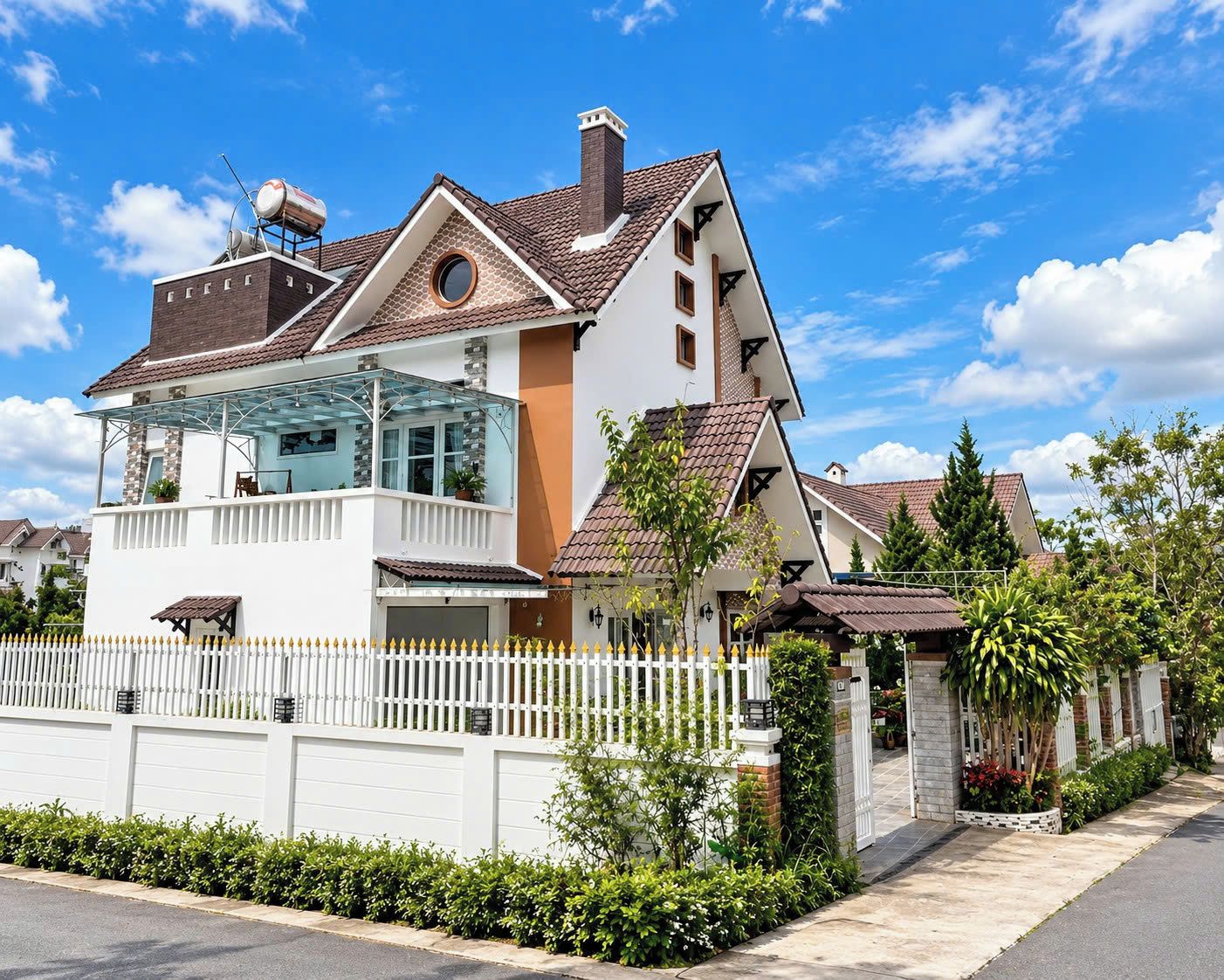 Une maison à deux étages avec un balcon, un garage et une cour clôturée.