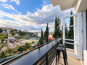 Un balcón con vistas a un paisaje urbano, con edificios y zonas verdes.