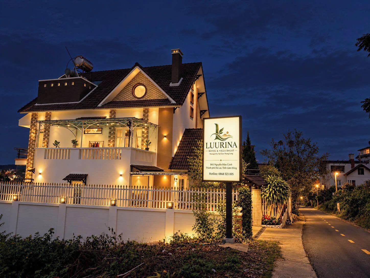 Un hôtel à deux étages doté d’un balcon, d’une enseigne et d’une entrée bien éclairée.