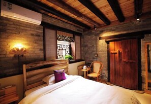 Une chambre à coucher avec un lit en bois, une chaise, une fenêtre donnant sur un beau paysage et une armoire en bois.