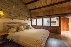 A wooden room with a bed, a brick wall, and a window. - GOVERNORS MANSION YANGSHOU (Guilin)