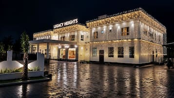 Hotel amb façana moderna, entrada coberta i exterior ben il·luminat.