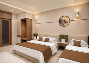 A modern bedroom with a large bed, bedside tables, a mirror, and wall-mounted lighting. - Aryan Inn Hotel (Varanasi)