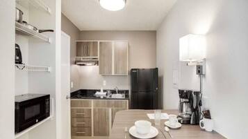 Una cocina compacta equipada con microondas, refrigerador y cafetera.