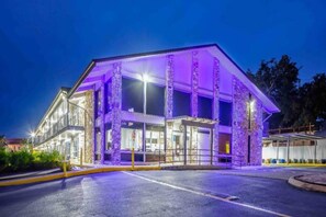Un edificio con techo plano, grandes ventanales y un área de acceso cubierta.