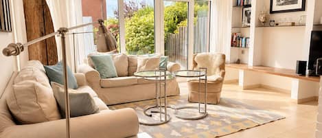 A living room with a sofa, armchair, coffee table, and floor lamp.