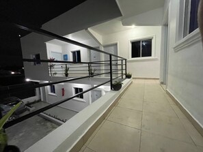 Un interior modern amb una escala, un balcó i vistes a l'exterior.